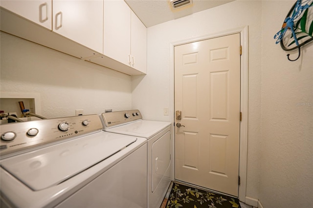 laundry room featuring washer and dryer, cabinet space, and visible vents