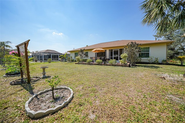 rear view of property with a yard and stucco siding