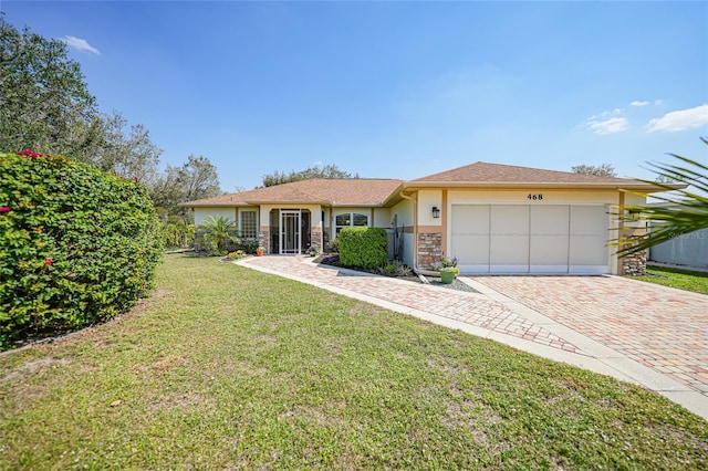 view of front of property with an attached garage, stone siding, decorative driveway, stucco siding, and a front lawn