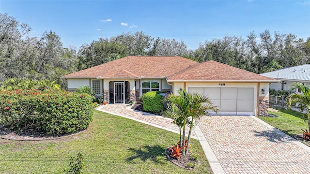 single story home with decorative driveway, stucco siding, an attached garage, stone siding, and a front lawn