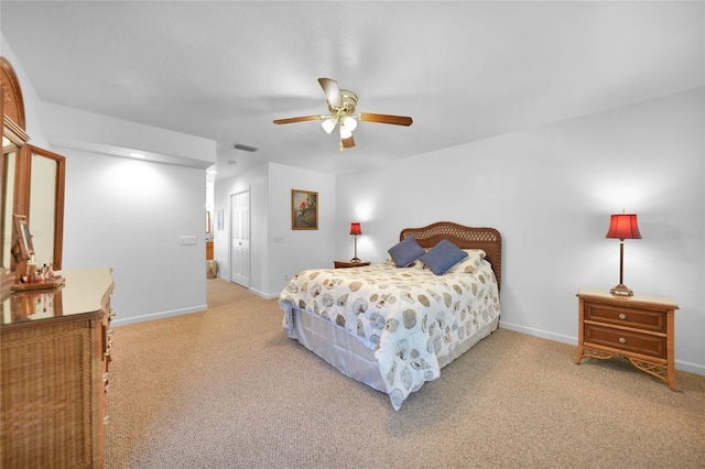 carpeted bedroom featuring a ceiling fan, a closet, visible vents, and baseboards