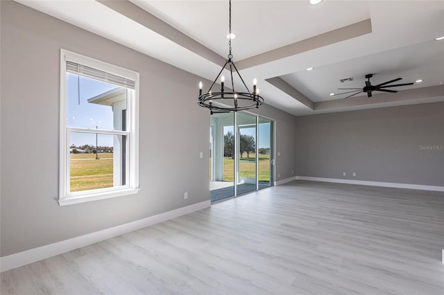 unfurnished room with recessed lighting, a raised ceiling, visible vents, wood finished floors, and baseboards