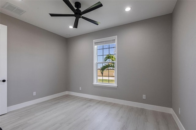 empty room with light wood finished floors, baseboards, and visible vents