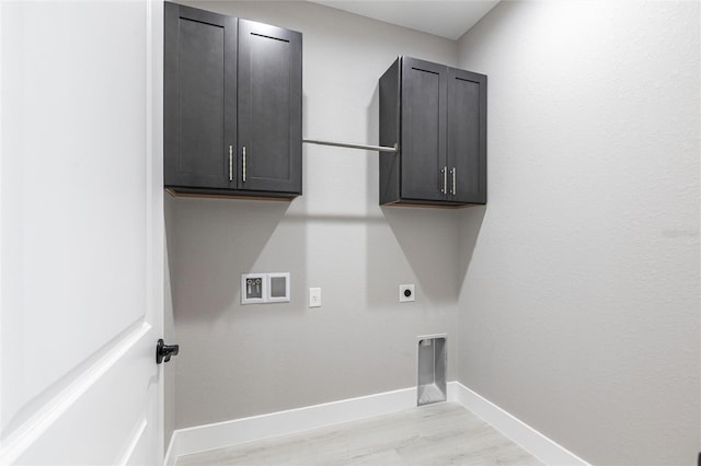 laundry area featuring hookup for an electric dryer, washer hookup, baseboards, light wood-type flooring, and cabinet space