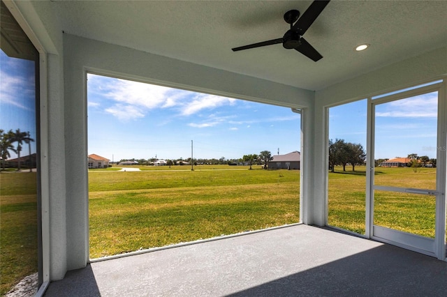 unfurnished sunroom with ceiling fan