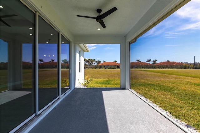 unfurnished sunroom with ceiling fan