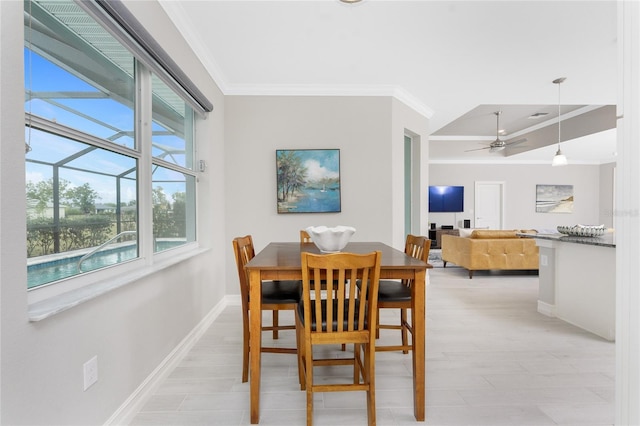 dining space featuring baseboards, light wood-type flooring, a ceiling fan, and crown molding