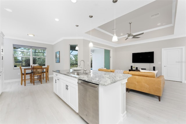 kitchen featuring a sink, visible vents, dishwasher, a raised ceiling, and a center island with sink