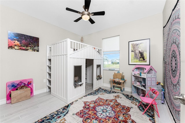 bedroom with a ceiling fan, baseboards, and wood finished floors