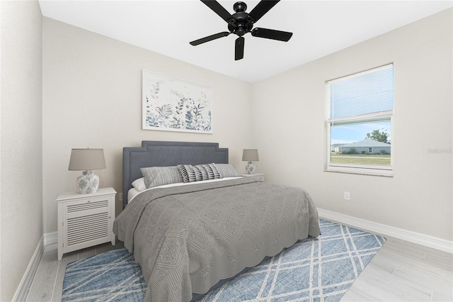 bedroom with ceiling fan, baseboards, and wood finished floors