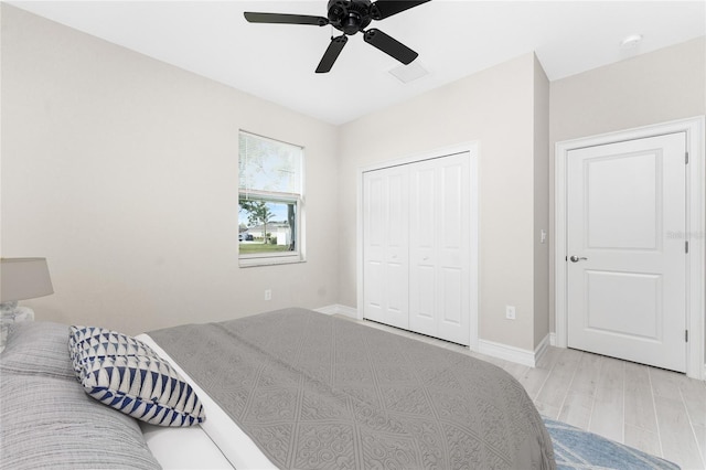 bedroom with ceiling fan, a closet, baseboards, and wood finished floors