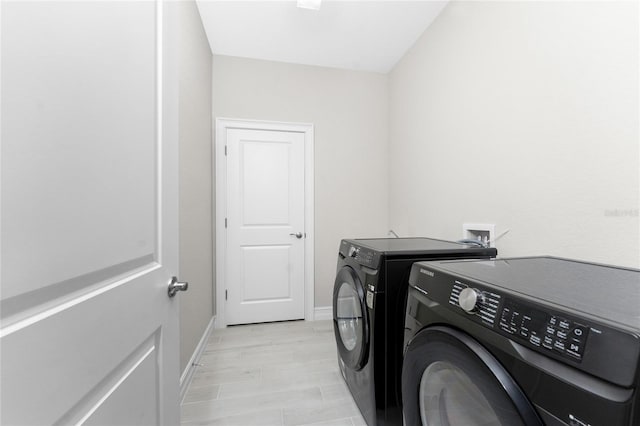 laundry room with laundry area, baseboards, and washer and dryer