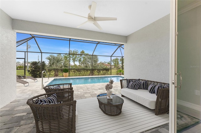 view of patio / terrace with an outdoor pool, glass enclosure, outdoor lounge area, and a ceiling fan