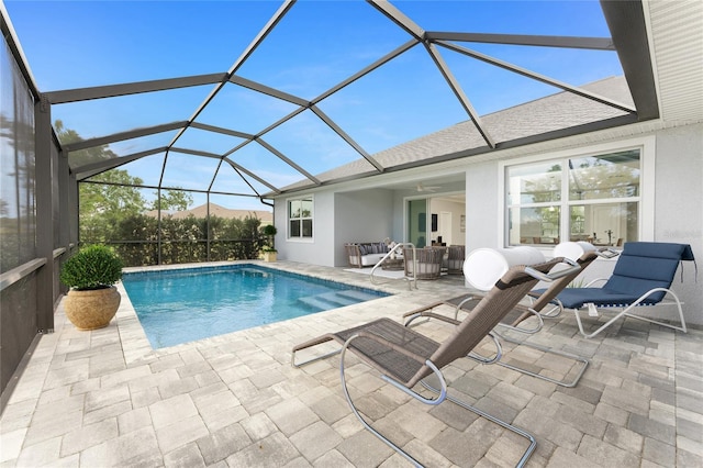 pool with a patio area, ceiling fan, glass enclosure, and an outdoor living space