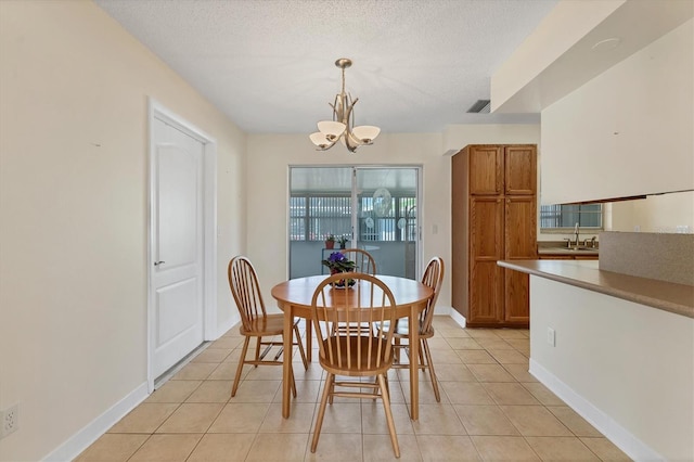 dining space featuring visible vents, an inviting chandelier, light tile patterned flooring, a textured ceiling, and baseboards