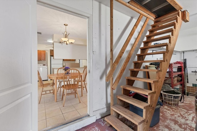stairway featuring washer / clothes dryer and tile patterned flooring