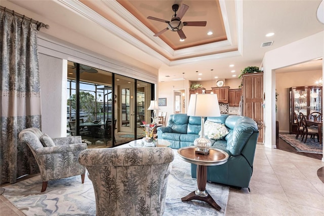 living room with visible vents, a ceiling fan, crown molding, light tile patterned floors, and a raised ceiling