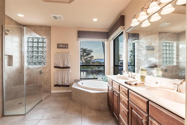 full bathroom with a sink, visible vents, and tiled shower