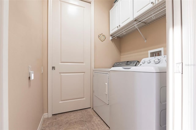 washroom with washer and dryer, baseboards, and cabinet space