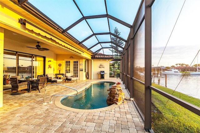 outdoor pool with glass enclosure, french doors, an outdoor hangout area, a patio area, and a ceiling fan