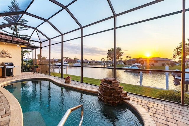 outdoor pool featuring a lanai, area for grilling, a patio area, and a water view