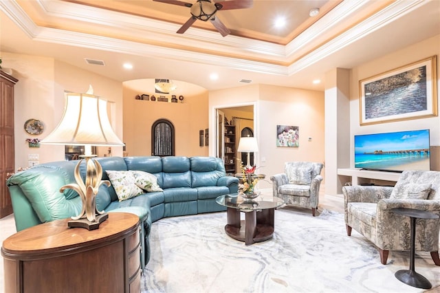 living room with visible vents, crown molding, and a tray ceiling