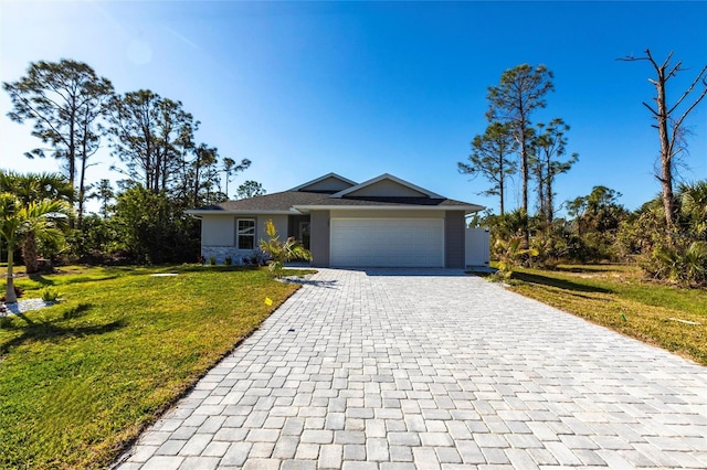 single story home featuring an attached garage, a front lawn, decorative driveway, and stucco siding