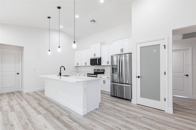 kitchen featuring stainless steel appliances, light countertops, white cabinetry, a sink, and high vaulted ceiling