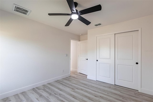 unfurnished bedroom with light wood finished floors, baseboards, visible vents, and a closet