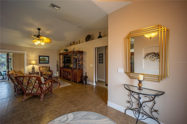 living room with lofted ceiling, visible vents, a ceiling fan, tile patterned flooring, and baseboards