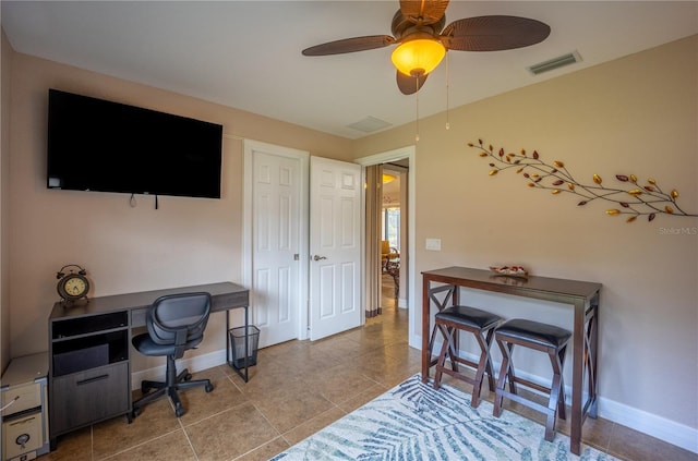 tiled office space with a ceiling fan, visible vents, and baseboards