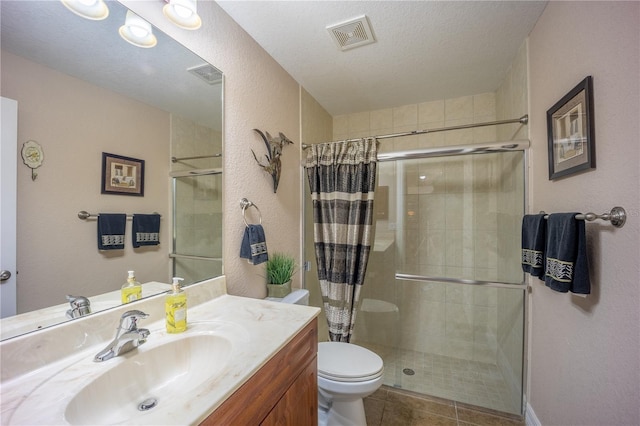 full bathroom with a textured ceiling, vanity, a shower stall, and visible vents