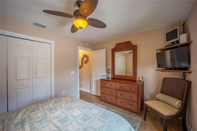 tiled bedroom with a closet, visible vents, ceiling fan, and baseboards