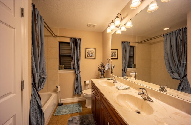 bathroom featuring a textured ceiling, toilet, a sink, and visible vents