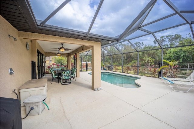 outdoor pool with a lanai, a patio area, a ceiling fan, and outdoor dining space