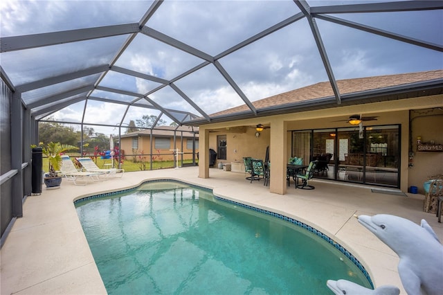 outdoor pool with a patio area, ceiling fan, and glass enclosure