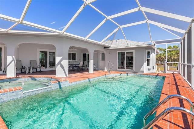 view of swimming pool with a patio area, glass enclosure, a pool with connected hot tub, and ceiling fan