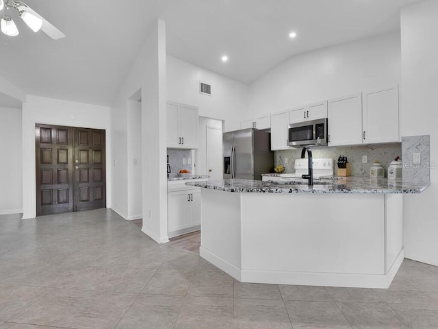 kitchen with stainless steel appliances, white cabinetry, visible vents, and light stone countertops