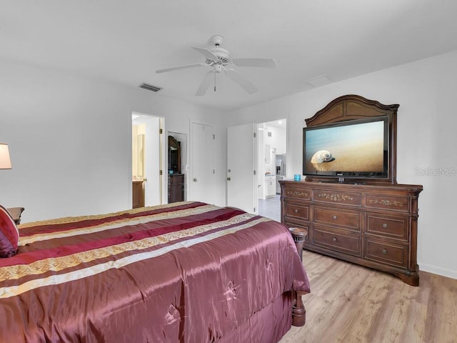 bedroom featuring light wood finished floors, baseboards, visible vents, a ceiling fan, and ensuite bathroom