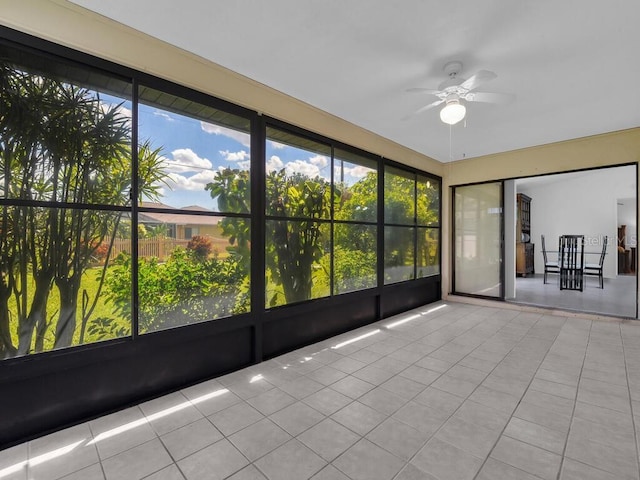 unfurnished sunroom featuring ceiling fan