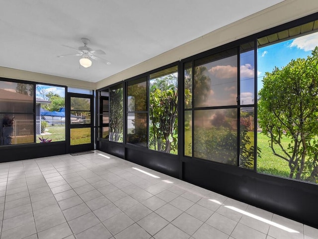 unfurnished sunroom featuring a ceiling fan