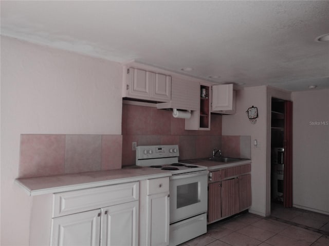 kitchen with white electric range oven, light countertops, backsplash, and light tile patterned flooring