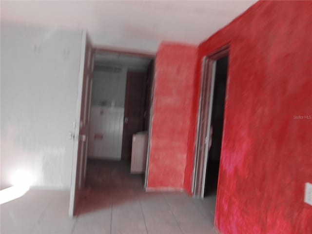 corridor with light tile patterned flooring and radiator heating unit