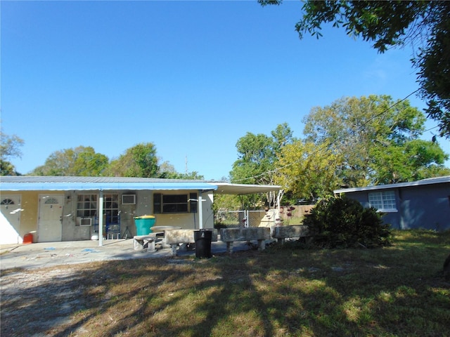 rear view of property with a yard, metal roof, and a patio