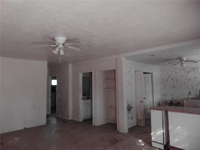 unfurnished bedroom with a ceiling fan and a textured ceiling