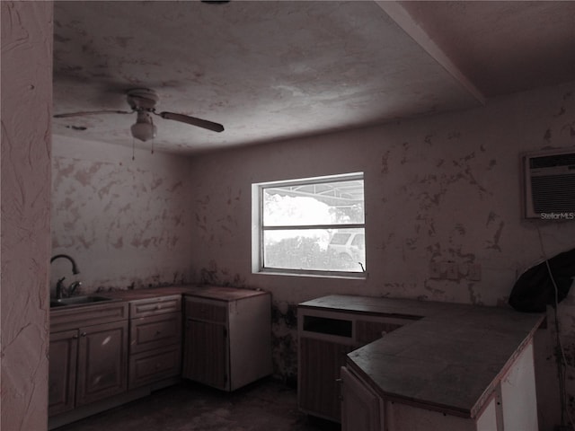 kitchen featuring a peninsula, ceiling fan, a sink, and a wall mounted AC