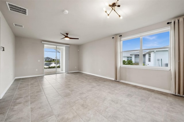 spare room featuring tile patterned flooring, ceiling fan, visible vents, and baseboards