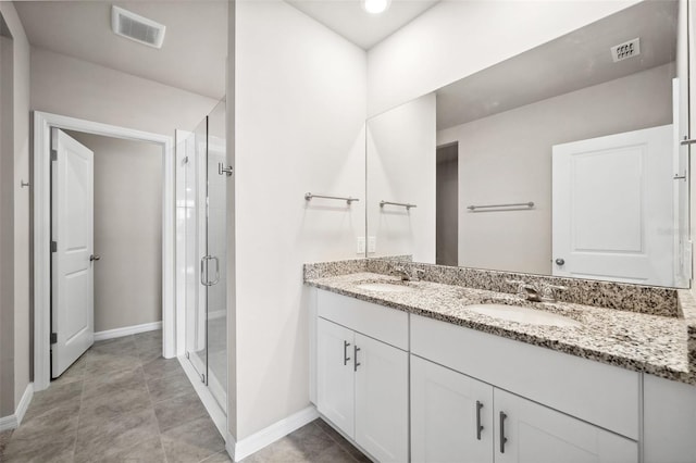 bathroom featuring double vanity, a shower stall, visible vents, and a sink