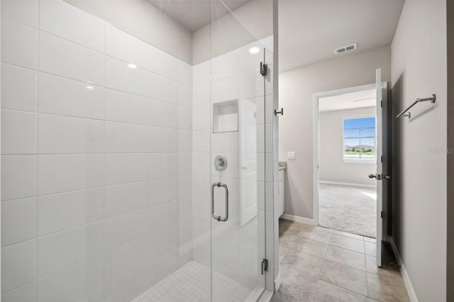 bathroom featuring baseboards, a shower stall, visible vents, and tile patterned floors