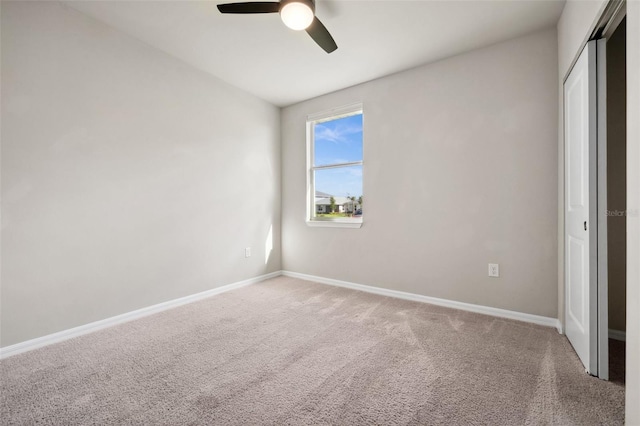 unfurnished bedroom featuring baseboards, ceiling fan, a closet, and light colored carpet